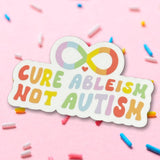 Sticker with 'Cure Ableism Not Autism' text on a pink background with sprinkles
