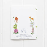 The back of the lesbian coming out card from Yardia also features watercolor floral illustrations in the colors of the lesbian WLW pride flag.