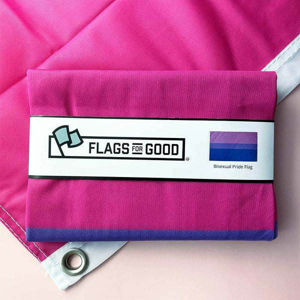 A folded Bisexual Pride flag sits on top of a flag that's been opened.