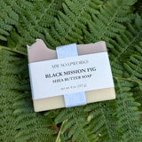 A four ounce bar of Black Mission Fig Shea Butter Soap from MW Soapworks sits on a bed of Pacific Northwest ferns.