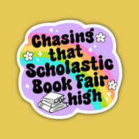 A rainbow and purple sticker has big bubble retro letters that say "Chasing that Scholastic Book Fair High" with a pile of books next to them.