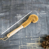 Cleaning brush with measurements on a textured gray background