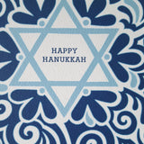 Image shows a close up of a blockprinted greeting card. Text reads "Happy Hannukah" in a star of David.