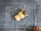 Wooden brush with measurements on a textured gray background