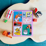Card with cartoon dog illustrations on a wooden surface with toys around