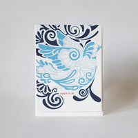 Image of a greeting card with a curvy dove design. Text on card reads "peace to all."