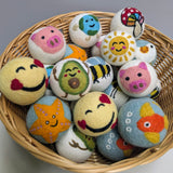 Basket of colorful felt toys with various designs on a light gray background