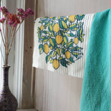 Image shows a lemon swedish dishcloth hanging to dry.