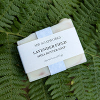 A four ounce bar of Lavender Field Shea Butter Soap from MW Soapworks sits on a Pacific Northwest fern background.
