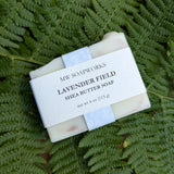 A four ounce bar of Lavender Field Shea Butter Soap from MW Soapworks sits on a Pacific Northwest fern background.