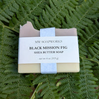 A four ounce bar of MW Soapworks Black Mission Fig Shea Butter Soap sits on a background of Pacific Northwest ferns.