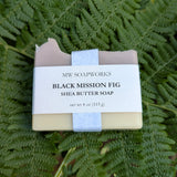 A four ounce bar of MW Soapworks Black Mission Fig Shea Butter Soap sits on a background of Pacific Northwest ferns.