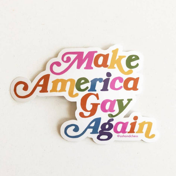A colorful text sticker sits against a white background. The text of the sticker reads "Make America Gay Again" in a fun and multi-colored script.