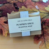 A bar of Pumpkin Spice Seasonal Soap from MW Soapworks sits on colorful fall leaves.