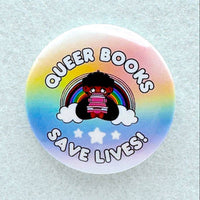 A pin features a cartoon cutie sitting with a stack of books in front of a rainbow and big bubble letters that say "Queer books save lives!"