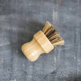 Wooden dish brush on a textured gray surface