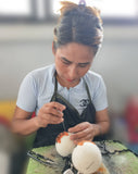Person working on felting a wool dryer ball with a blurred background